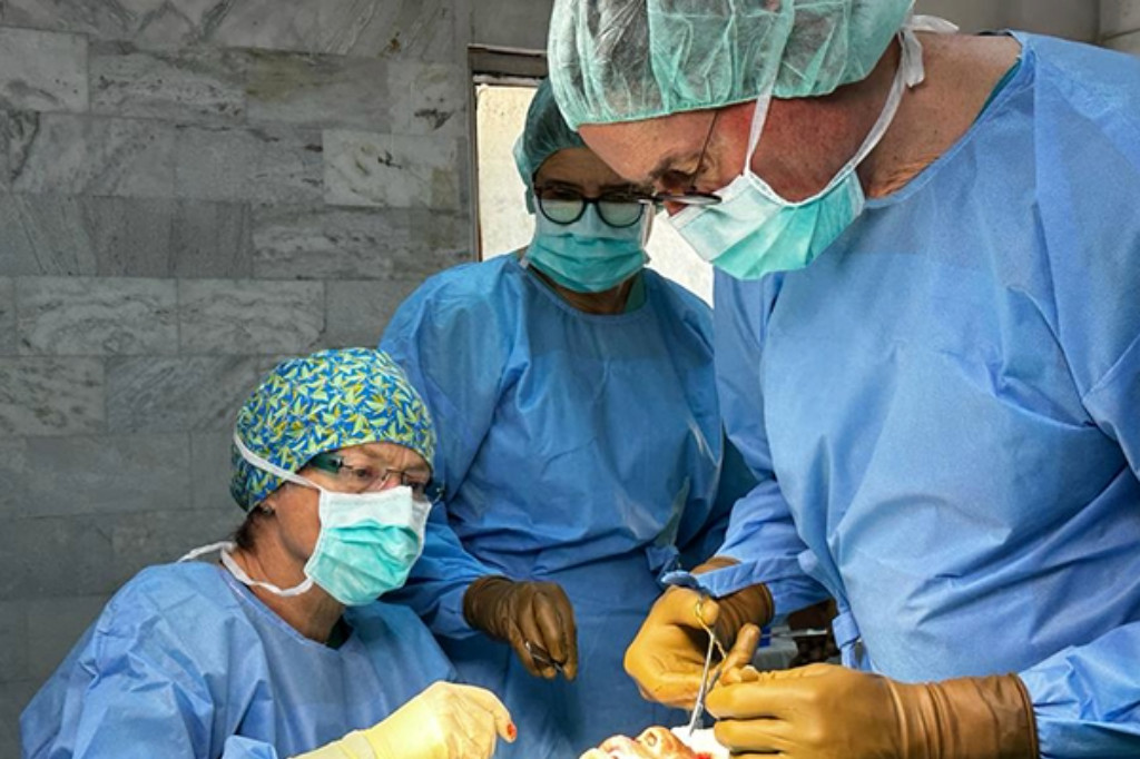 Cirurgiões operam um paciente com queimaduras.