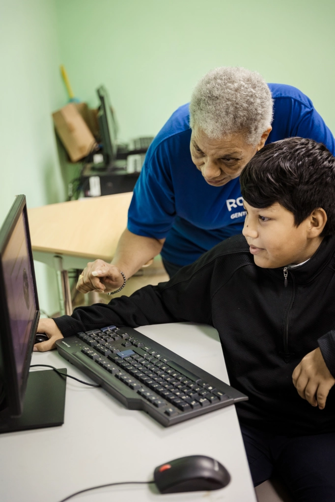 Enedelsy Escobar ajuda o aluno Enoc Vasquez com o seu trabalho de aula.